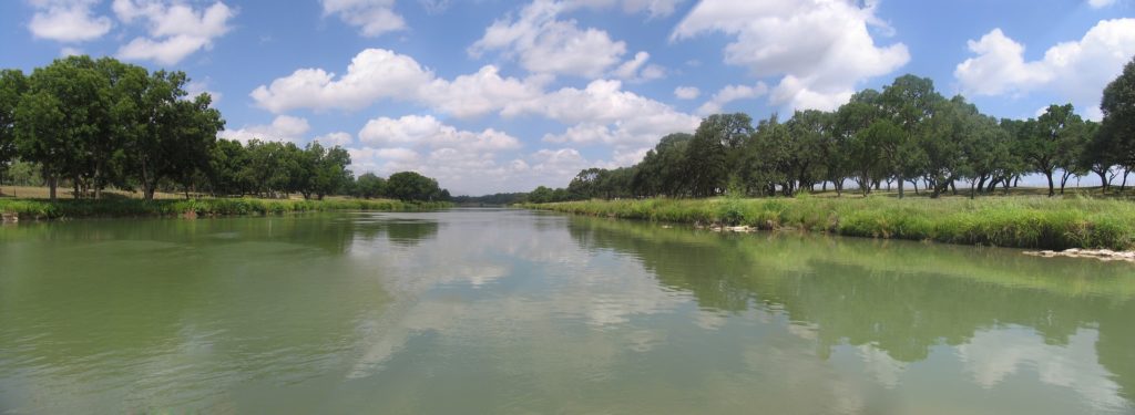 Texas river with grass and trees on each side